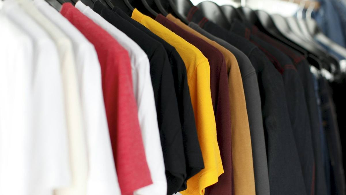 Shirts in white, red, yellow and black hanging on a clothes rail