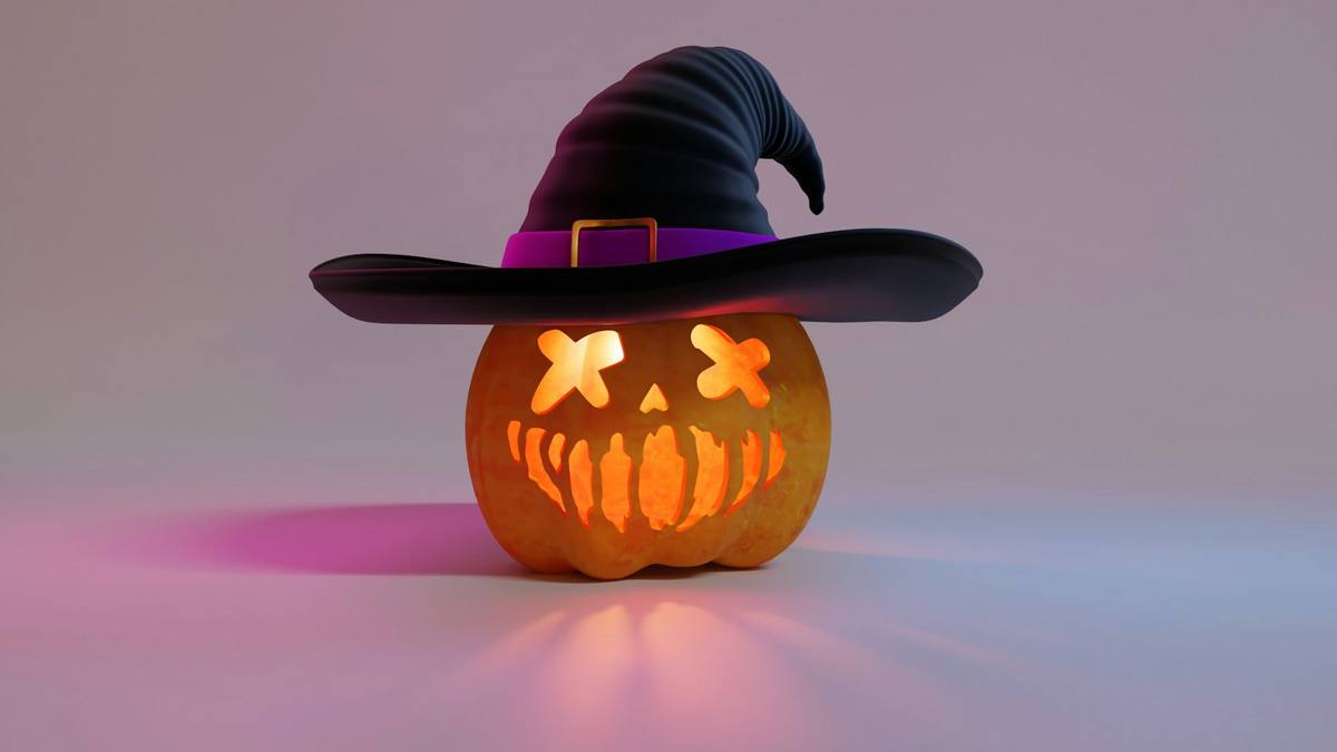 A carved pumpkin wearing a black witch's hat