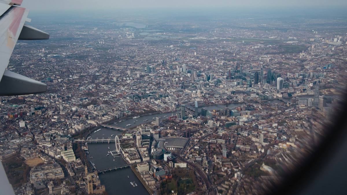 Central London seen from an aircraft window, with the wing at the left and the Thames curving past the London Eye, Waterloo station and the City
