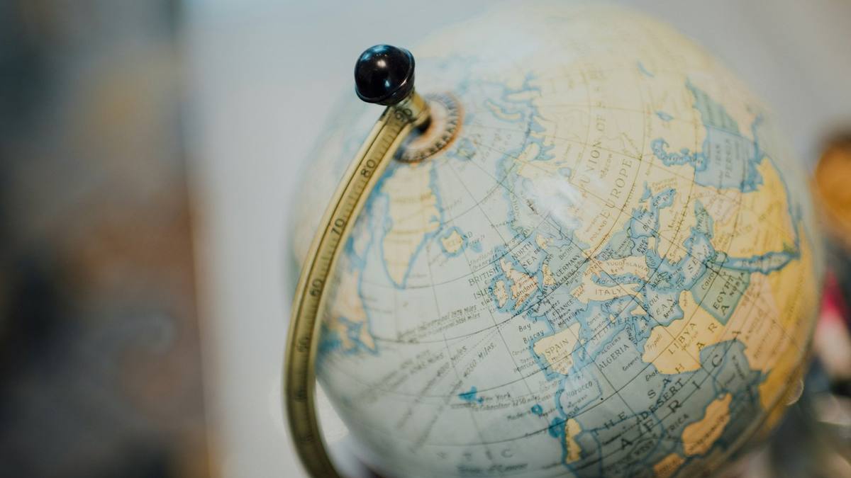 Close-up of an antique desk globe showing Europe and North Africa, with a brass meridian ring