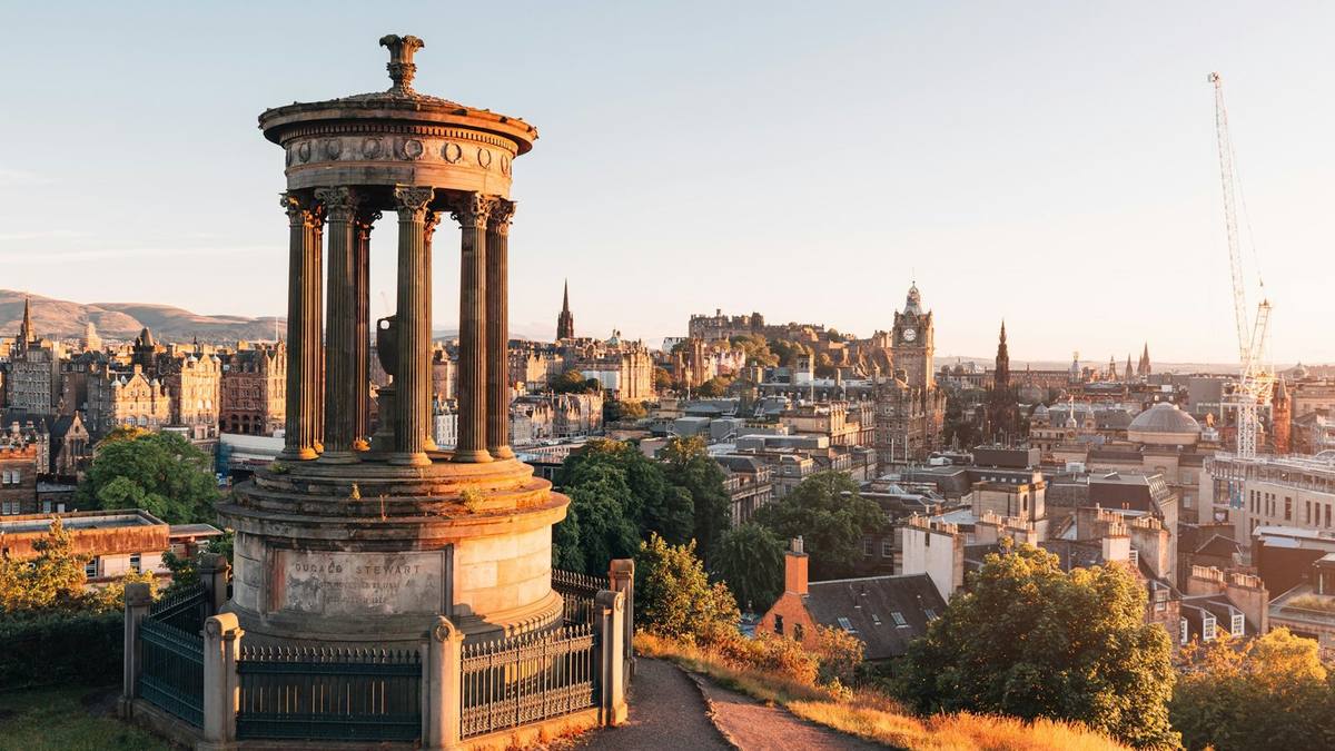 The Dugald Stewart Monument on Calton Hill with Edinburgh Castle and the Old Town skyline behind at sunset