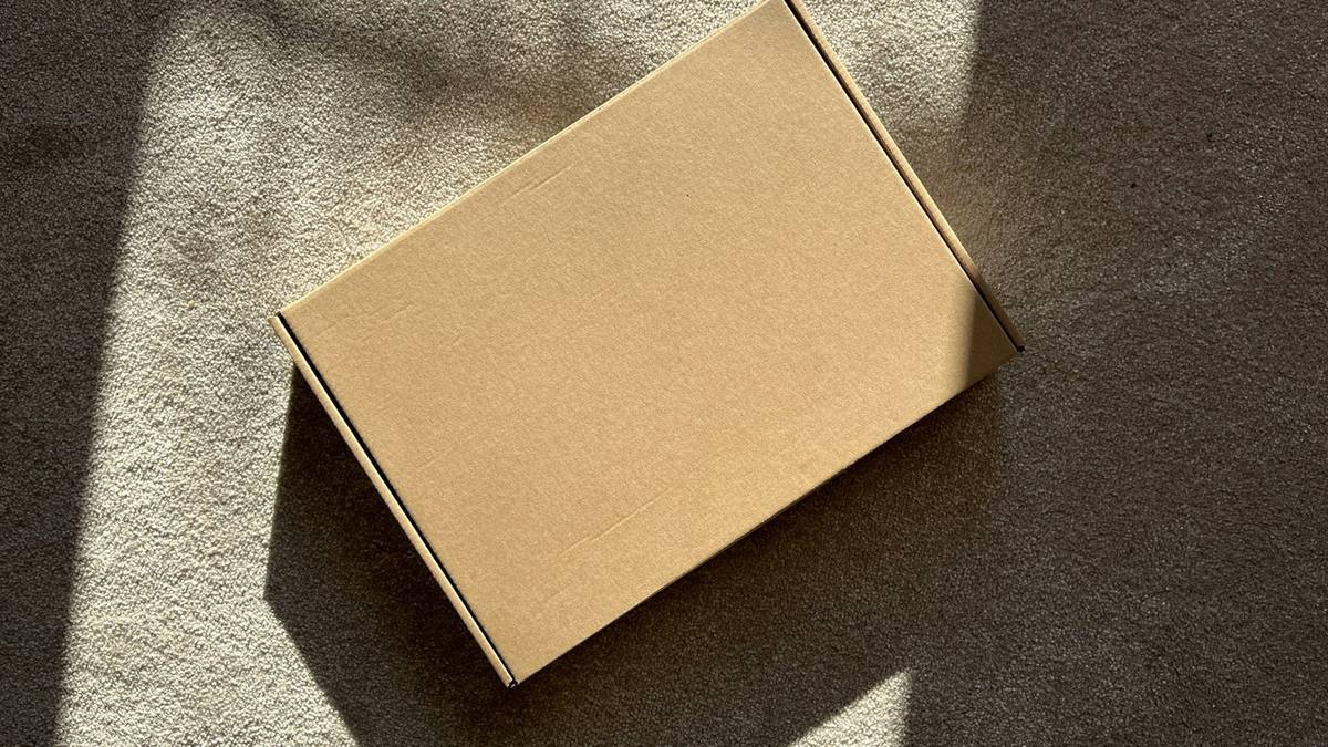 A plain cardboard box on a textured surface
