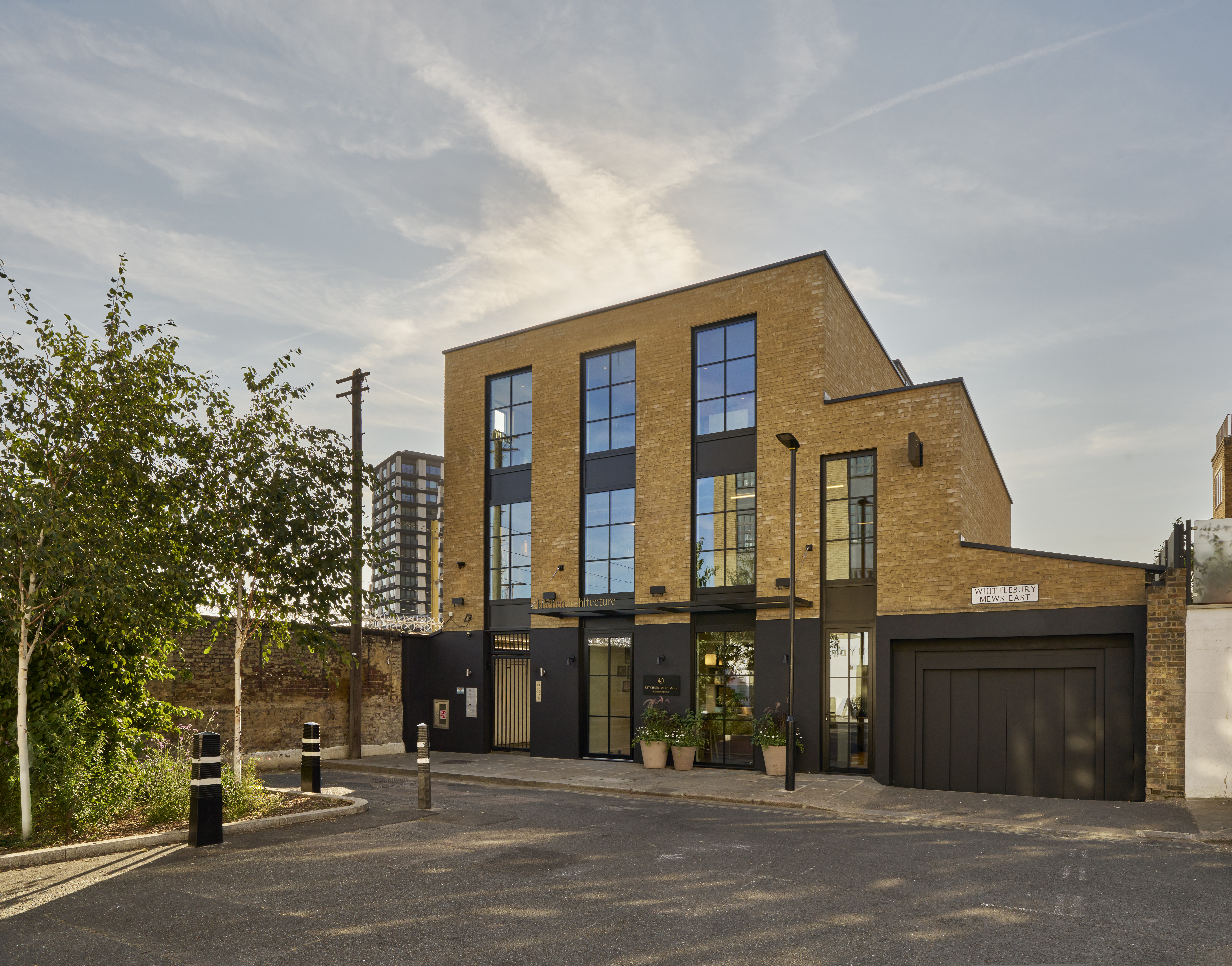 Kitchen Architecture Primrose Hill: a four-storey yellow-brick building with black-framed windows on Whittlebury Mews East, London NW1
