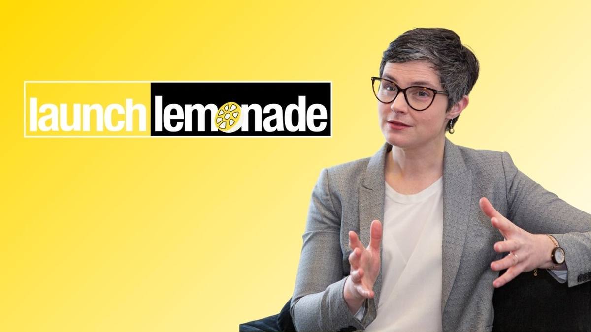 Chloe Smith, wearing glasses and a grey blazer, speaking on a yellow background featuring the LaunchLemonade logo.