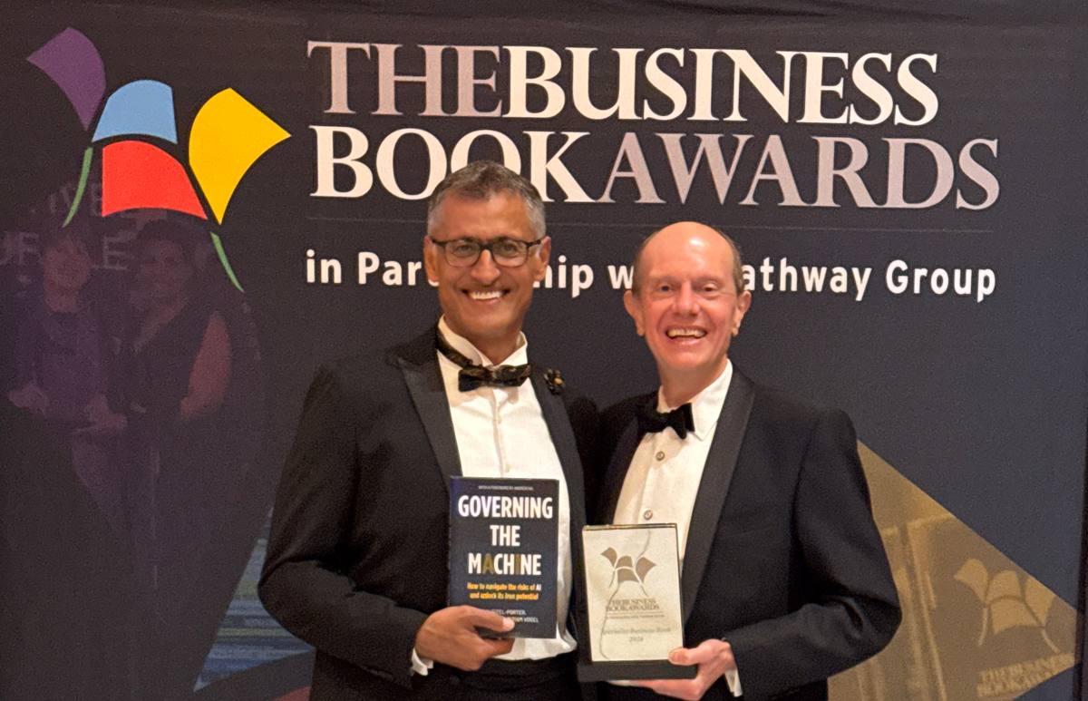 Dr Paul Dongha and Ray Eitel-Porter hold their book and the award trophy in front of The Business Book Awards banner