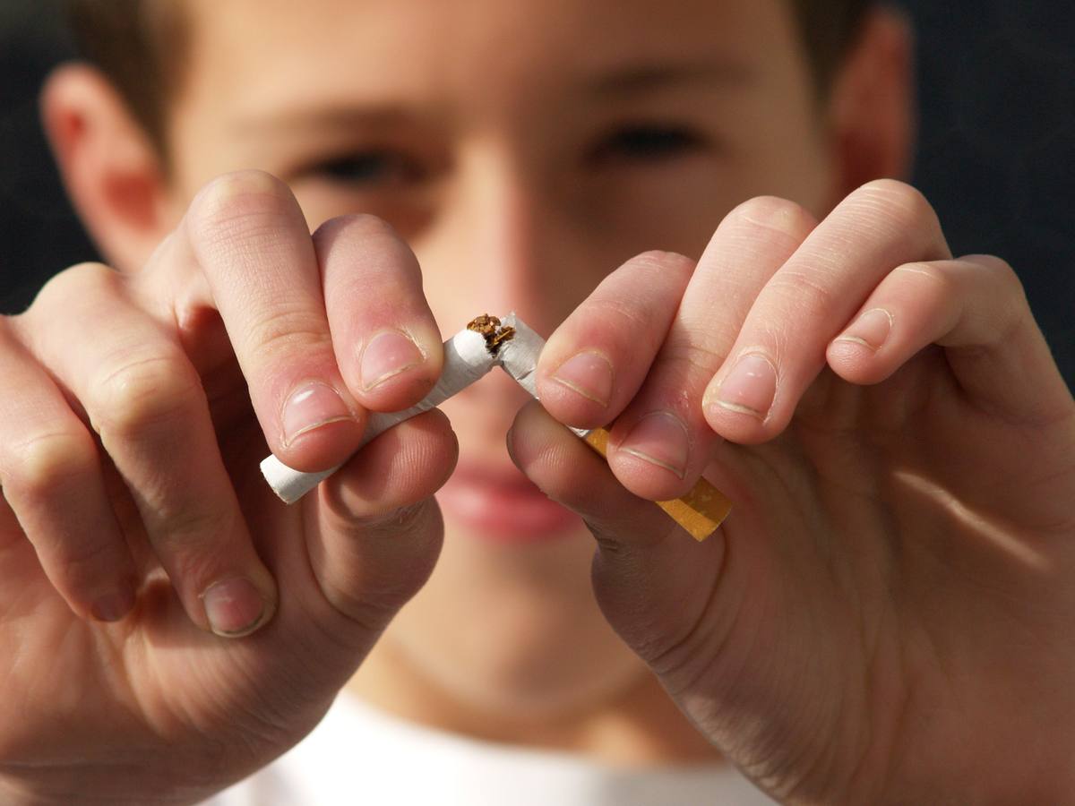 Person breaking cigarette in half