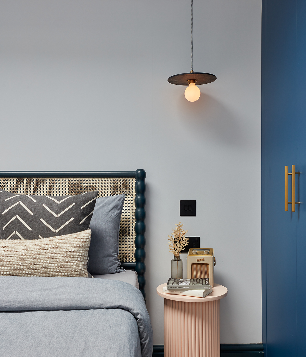 A contemporary blue-themed bedroom featuring a pendant light from Spark & Bell.