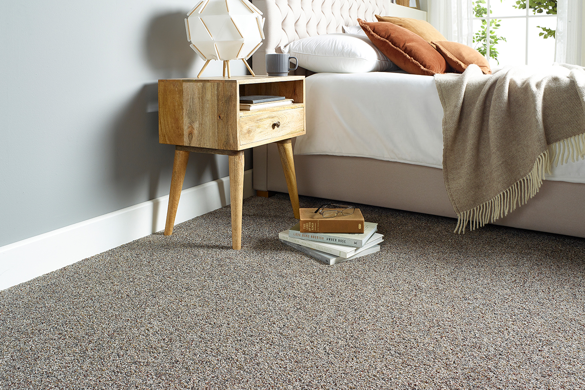 A cosy, contemporary bedroom featuring a mottled grey carpet from Abingdon Flooring.